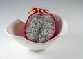 Dragon fruit cut in half in a white bowl against a grey background Royalty Free Stock Photo