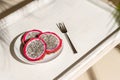 Dragon fruit, pitaya on a white wooden tray on the sand of tropical beach under a palm tree. Exotic food, snack. Summer travel. Royalty Free Stock Photo