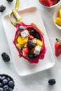 A dragon fruit shell filled with a fresh fruit salad, ready for eating. Royalty Free Stock Photo