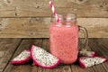 Dragon fruit smoothie with fruit slices on wood