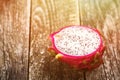 Dragon fruit on wooden table. Half pink pitaya, copy space. Tropical Fruits. Organic tropical sweet exotic pitaya. Healthy food.