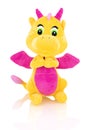 Dragon plushie doll isolated on white background with shadow reflection. Yellow stuffed dragon with purple horns and wings.