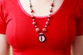 Dragon red eye cabochon and ceramic beads. necklace on a young girl on a red background