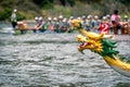 Dragon`s head with dragon boat racing team at the back