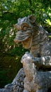 Dragon sculpture attacked by a lion in the sacred wood of Bomarzo. a natural park adorned with numerous basalt sculptures