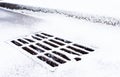 Drain grate covered with snow Royalty Free Stock Photo