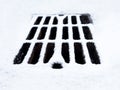 Drain grate covered with snow Royalty Free Stock Photo