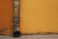 Drain pipe in front of the yellow wall Royalty Free Stock Photo
