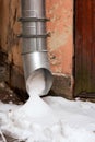 Metal water pipe on the corner of the house is filled with snow Royalty Free Stock Photo