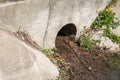 Drain pipe or hole for excess rainwater and wastewater under the asphalt road with water Royalty Free Stock Photo