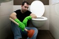 Drain Problems, blockage plumbing toilet unclog plunger force cup man sit floor Royalty Free Stock Photo