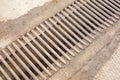 Drainage channel with a grate made of iron rods. Royalty Free Stock Photo