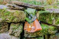 Drainage outlet of a pond between the rocks of a mossy fence Royalty Free Stock Photo