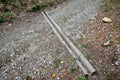 Drainage trough across the forest path for logging. two poles connected by a metal clamp serve as rainwater drainage in the rain.