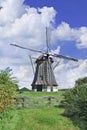 Drainage windmill with thatched roofing in a polder with dramatic shaped clouds and blue sky, Netherlands Royalty Free Stock Photo