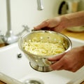 Draining spaghetti in the sink with colander. Conceptual image