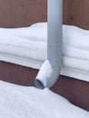 Drainpipe near the wall of a house in winter