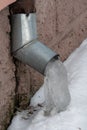 The drainpipes are covered with ice and snow. After a heavy snowstorm, the city is covered with snow and ice. There are many