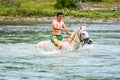 Draj-Rec, Albania - July 27, 2014. Young albanian boy riding on the white horse in Black Drin river in summer