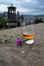 Dram glass of single malt scotch whisky and view from Calton hill to park and old parts of Edinburgh city in rainy day, Scotland, Royalty Free Stock Photo