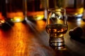 Dram of single malt scotch whisky and bottles on background