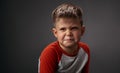 Drama boy showing with his face I Dont Like You to his parents isolated on grey background. Fake child emotions. Human Royalty Free Stock Photo