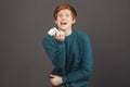 Drama queen. Close up portrait of funny attractive guy with ginger hair in comfortable green sweater feignedly crying Royalty Free Stock Photo