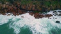 Dramatic aerial ocean crashing of dark coastal rocks. Waves breaking of cliffs. Royalty Free Stock Photo