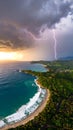 Dramatic aerial view of a tropical coastline with a powerful lightning strike during a sunset storm. Royalty Free Stock Photo