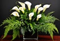 A dramatic arrangement of calla lilies and ferns