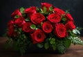 A dramatic arrangement of red roses and greenery