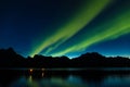 Dramatic aurora borealis, polar lights, over mountains in the North of Europe - Lofoten islands, Norway Royalty Free Stock Photo