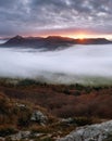 Dramatic autumn sunrise in mountain with red sky and clouds