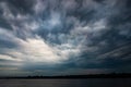 Dramatic beautiful stormy sky over the lake. Large gray rain and motley cloud above the horizon Royalty Free Stock Photo