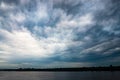 Dramatic beautiful stormy sky over the lake. Large gray rain and motley cloud above the horizon Royalty Free Stock Photo