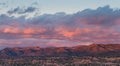 Dramatic, beautiful sunset casts purple and orange colors and hues on clouds and mountains Royalty Free Stock Photo