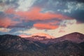 Dramatic, beautiful sunset casts purple and orange colors and hues on clouds and a snow-capped peak near Santa Fe, New Mexico Royalty Free Stock Photo