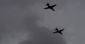 Dramatic black silhouettes of warplanes in flight in cloudy sky. Copy space
