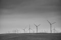 Dramatic black and white image of large wind turbines generators for alternative power and energy on a field in a farm. Royalty Free Stock Photo