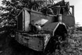 Dramatic black and white image of a old abandoned rusty truck in an overgrown field in the caribbean.