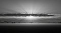 Dramatic black and white landscape showing sunrise clouds and rays Royalty Free Stock Photo