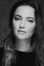 Dramatic black and white portrait of a beautiful lonely girl with freckles isolated on a dark background in studio shot Royalty Free Stock Photo