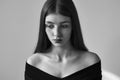 Dramatic black and white portrait of a beautiful lonely girl with freckles isolated on a white background in studio shot Royalty Free Stock Photo