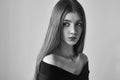 Dramatic black and white portrait of a beautiful lonely girl with freckles isolated on a white background in studio shot Royalty Free Stock Photo