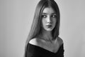 Dramatic black and white portrait of a beautiful lonely girl with freckles isolated on a white background in studio shot Royalty Free Stock Photo