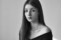 Dramatic black and white portrait of a beautiful lonely girl with freckles isolated on a white background in studio shot Royalty Free Stock Photo