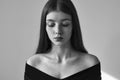 Dramatic black and white portrait of a beautiful lonely girl with freckles isolated on a white background in studio shot Royalty Free Stock Photo