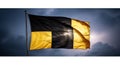 A dramatic black and yellow flag waves proudly against a deep blue sky with clouds and bright sunlight breaking through Royalty Free Stock Photo