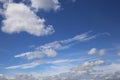 Dramatic blue clear summer sky background, white fluffy cumulus cloud over sea of cirrus clouds Royalty Free Stock Photo