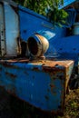 Dramatic blue image of a old abandoned rusty truck in an overgrown field in the caribbean.